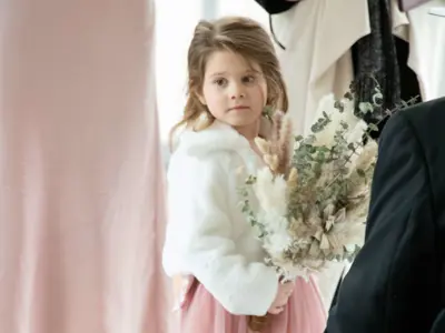 Young child in pink dress holding flowers
