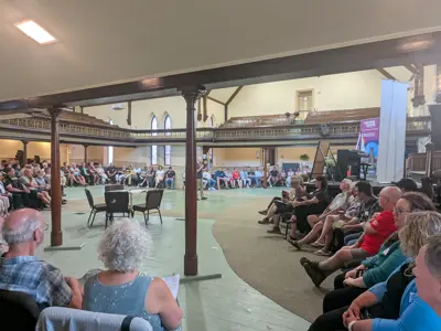 People sitting around a large room during the facilitated discussion