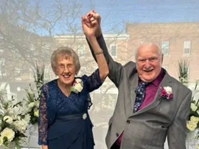 Couple holding hands in front of window
