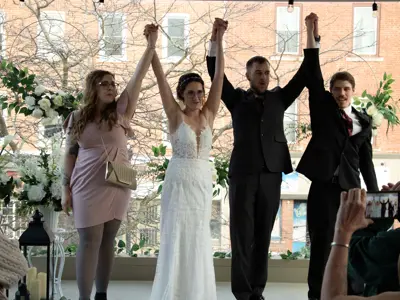 Four people holding hands up in celebration