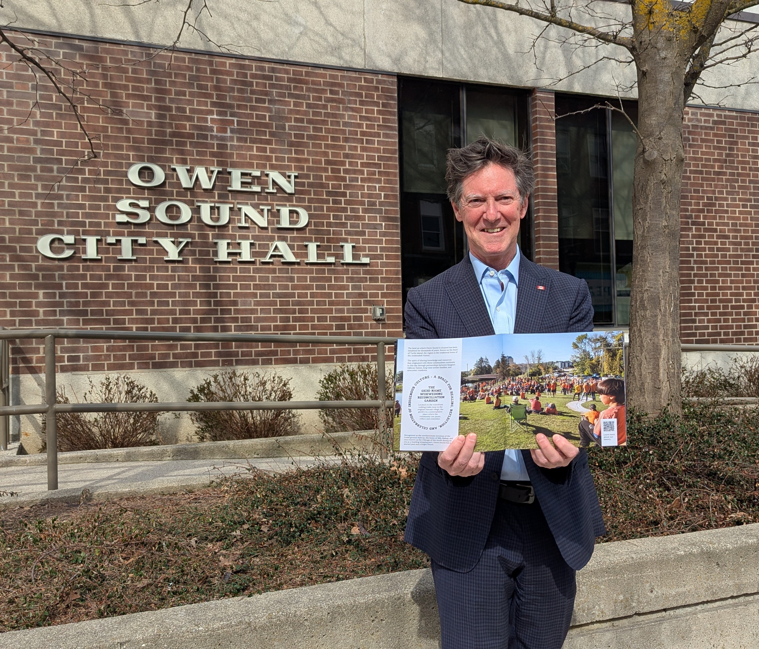 Mayor Boddy holding a copy of the new community profile print version