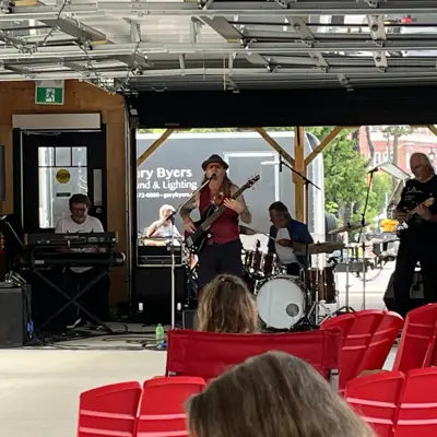 Person singing and playing a guitar in front of a crowd