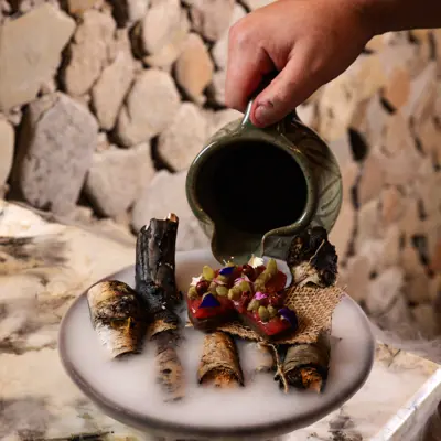 A chef pours liquid smoke over a tasty dish at Naagan.